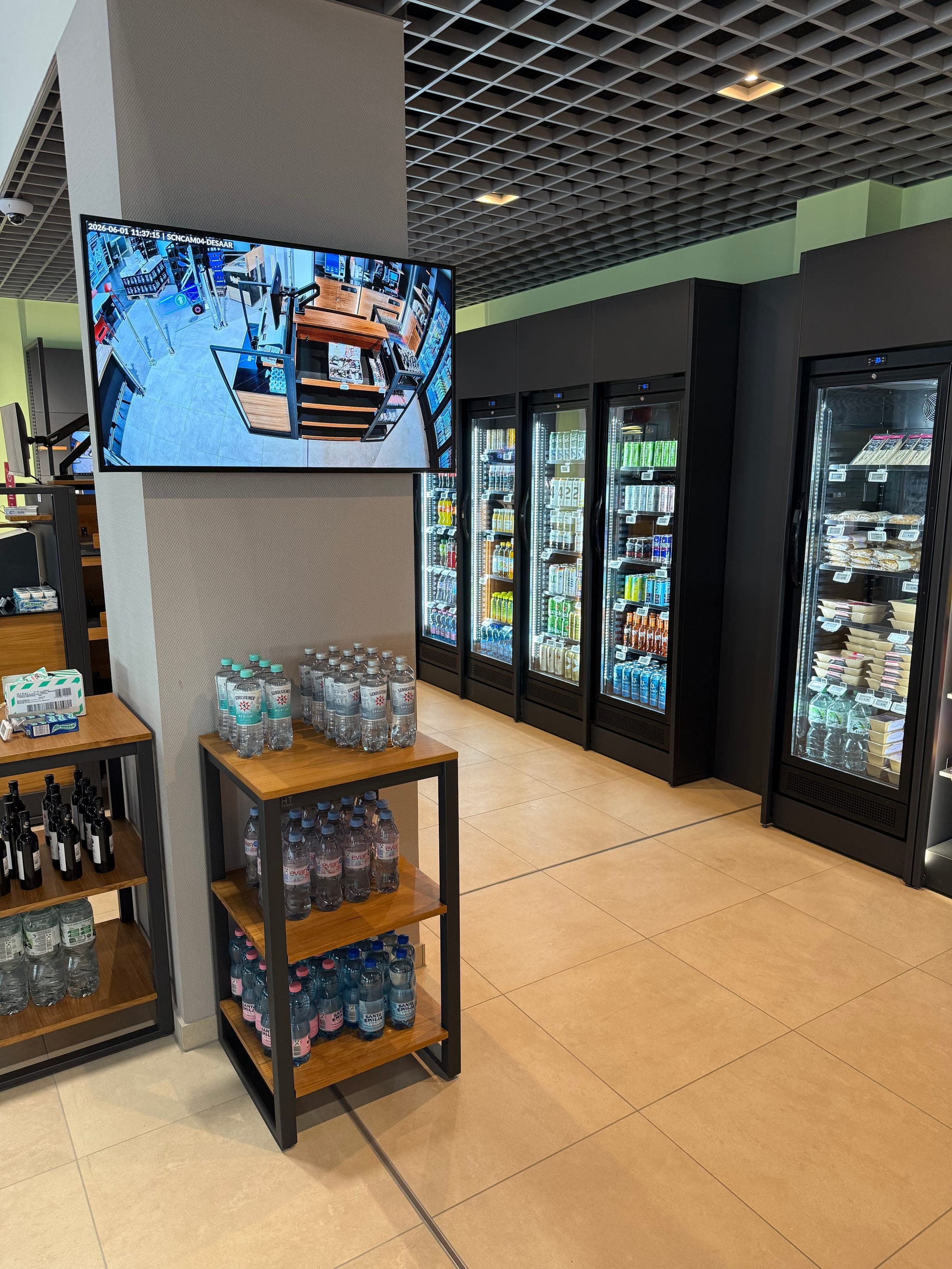 24/7-Shop am Flughafen Saarbrücken — Übersicht mit Getränken, Snacks und Live-Monitor der KI-Videoüberwachung