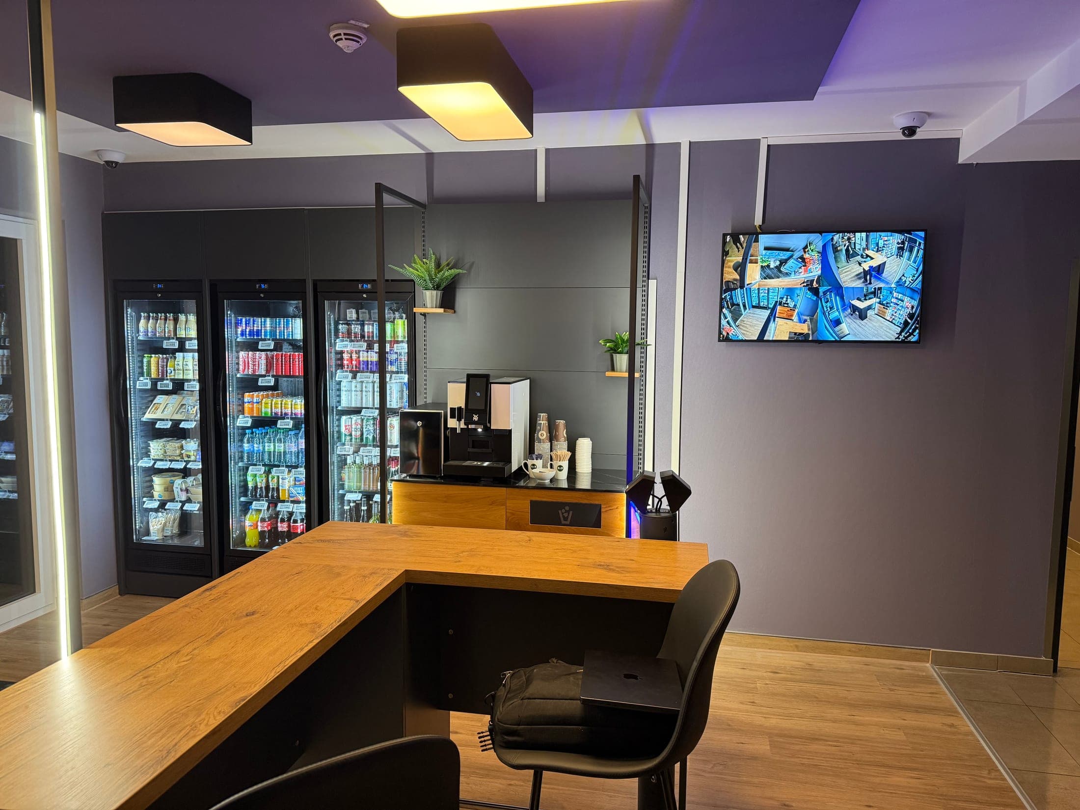Kühlschränke mit Getränken und Frischeprodukten, Kaffeevollautomat und Sitztresen im Shop des B&B Hotel Kaiserslautern