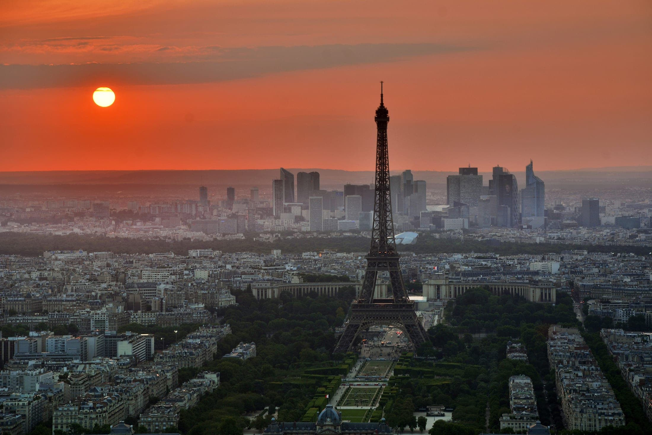 Paris bei Sonnenuntergang mit dem Eiffelturm und der Skyline von La Défense im Hintergrund