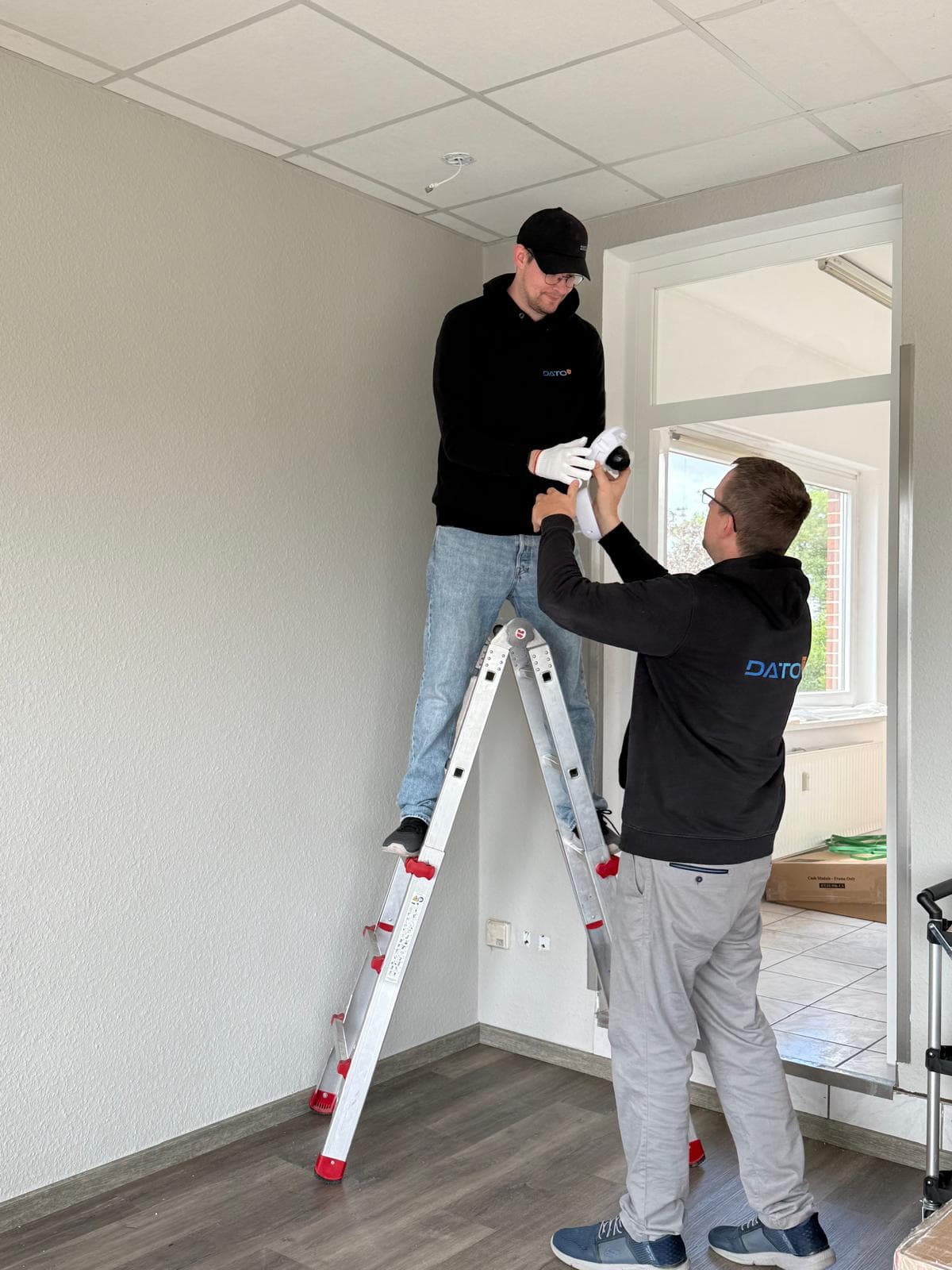 Kollegen installieren gemeinsam eine Überwachungskamera