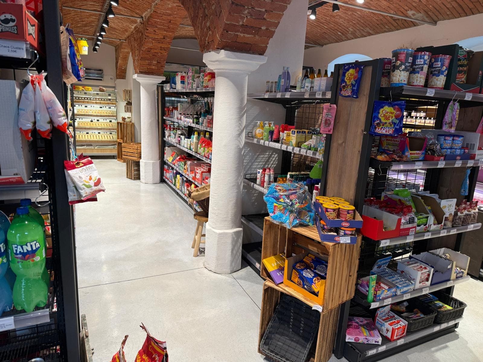 Vollsortiment im Immer(K)auf Taupadel — Regale mit Snacks, Getränken und Drogerieartikeln im Gewölberaum