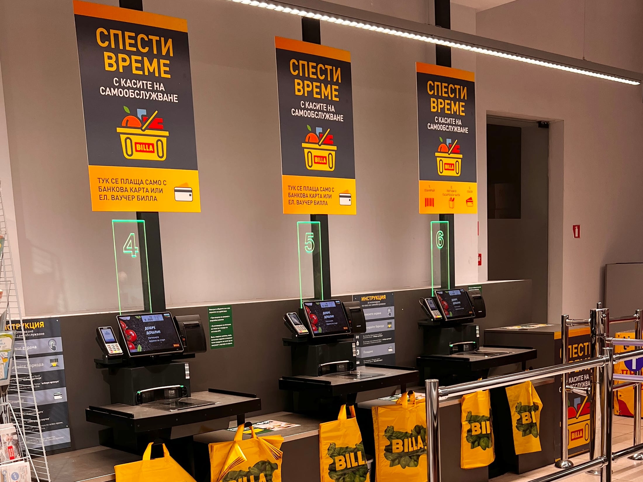 Drei nebeneinander stehende Self-Checkout-Kassen in einem Supermarkt